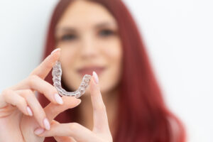 Pacjentka pokazuje nakładkę Invisalign